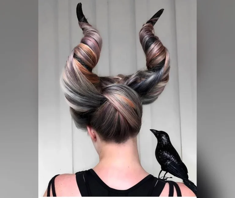 Sculpted hair horns with a crow prop worn as the featured look among halloween hairstyles for women