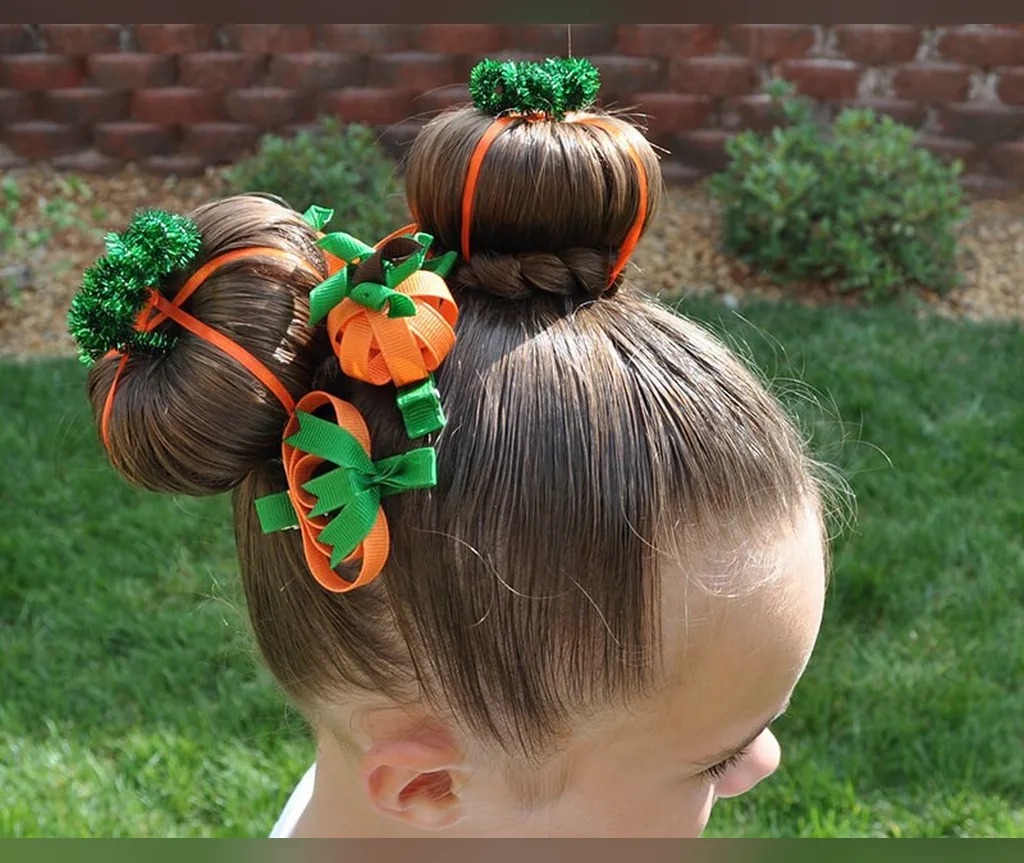 Two high pumpkin buns tied with long ribbons in halloween hairstyles for girls