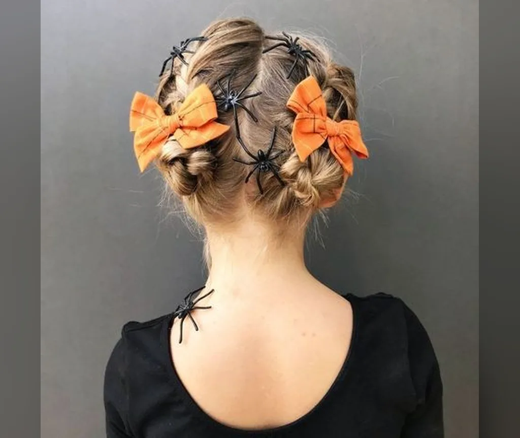 Back view of braided buns tied with orange bows and tiny spiders, halloween hairstyles for girls