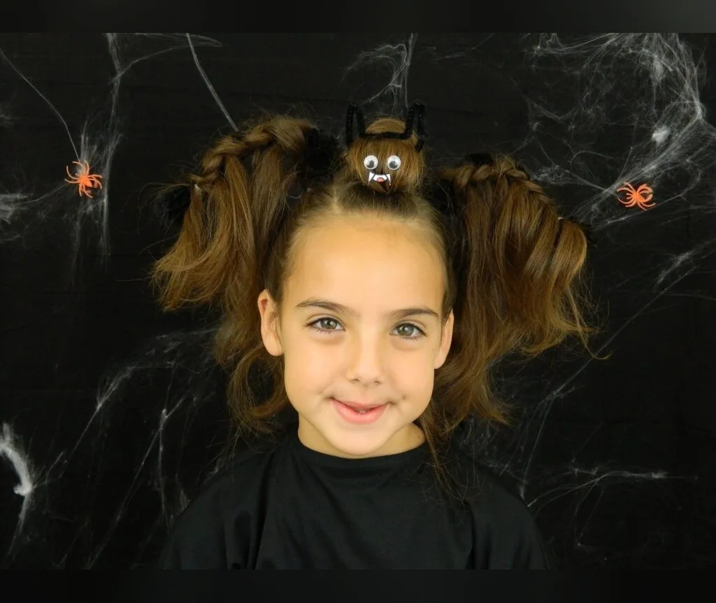 Puffy pigtails combined with a small bat decorated bun, halloween hairstyles for girls