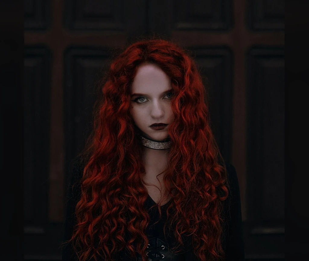 Dark red curls in a candlelit mood