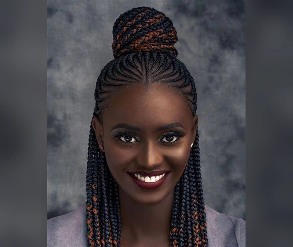 Cornrows with a top knot bun and copper-toned braids hanging down