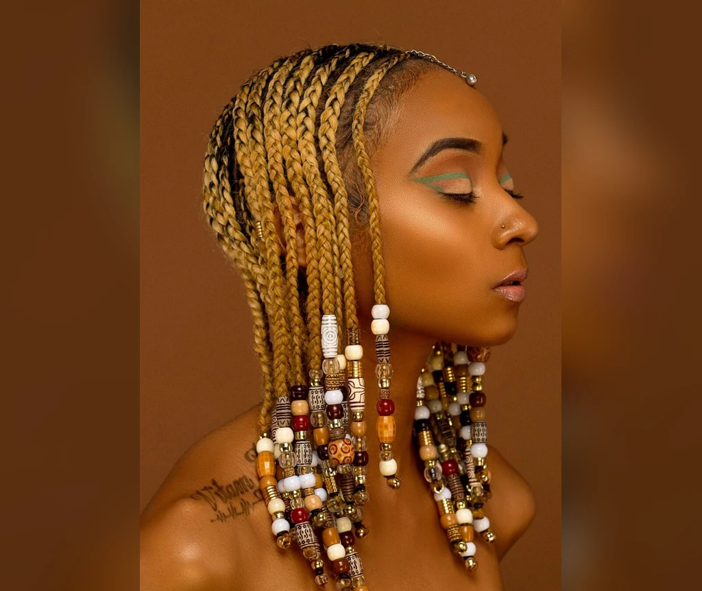 Blonde Ghana braids with beads in warm golden tones