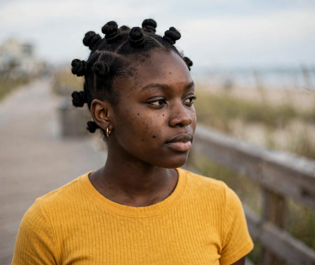 Black woman with bantu knots on a beach boardwalk