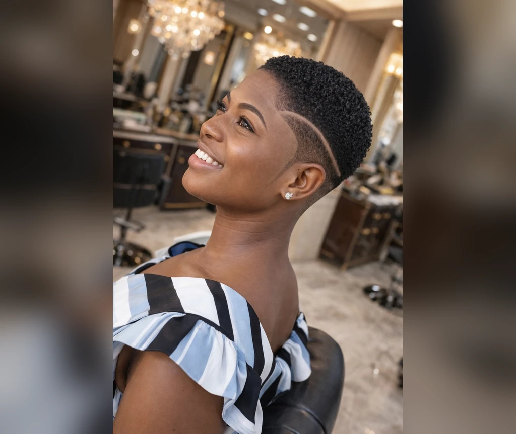 Short afro with a single line design on a laughing Black woman