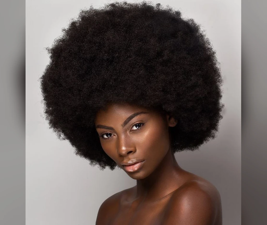 Classic afro on a Black woman with a full rounded shape